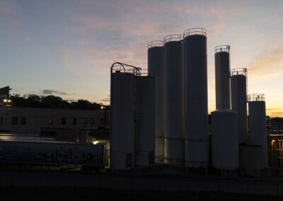 storage tanks at Hiland Dairy, Omaha location, silhouetted against the setting sun