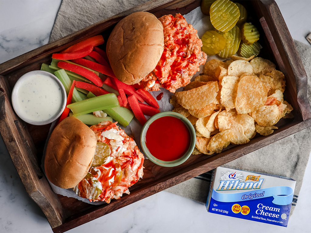 Slow Cooker Buffalo Chicken Sandwiches and condiments on a serving tray.