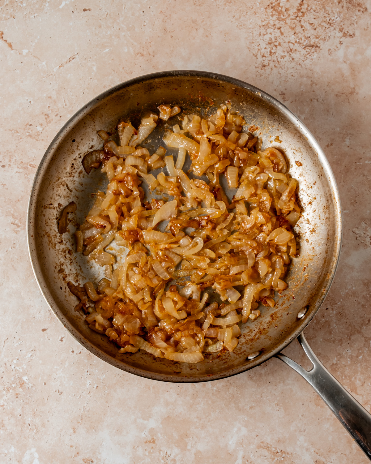 Caramelized onions in a frying pan, showing a rich golden-brown color.