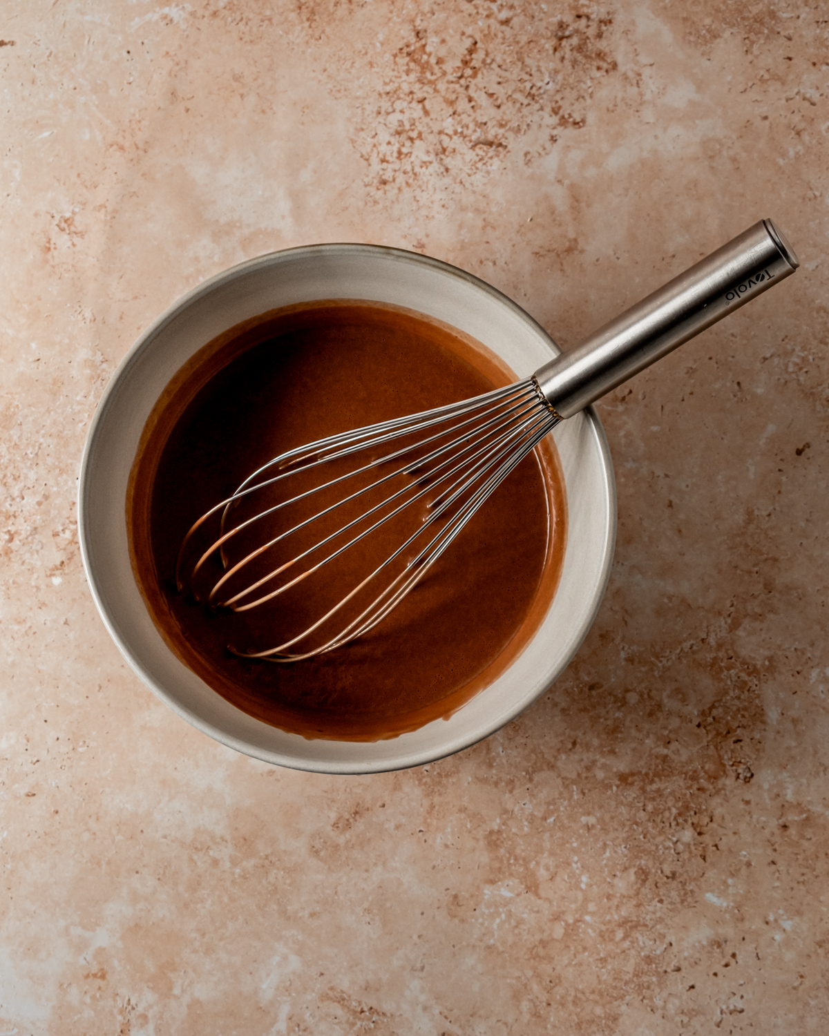 Overhead shot of the batter for Chocolate Crepes and a metal wisk