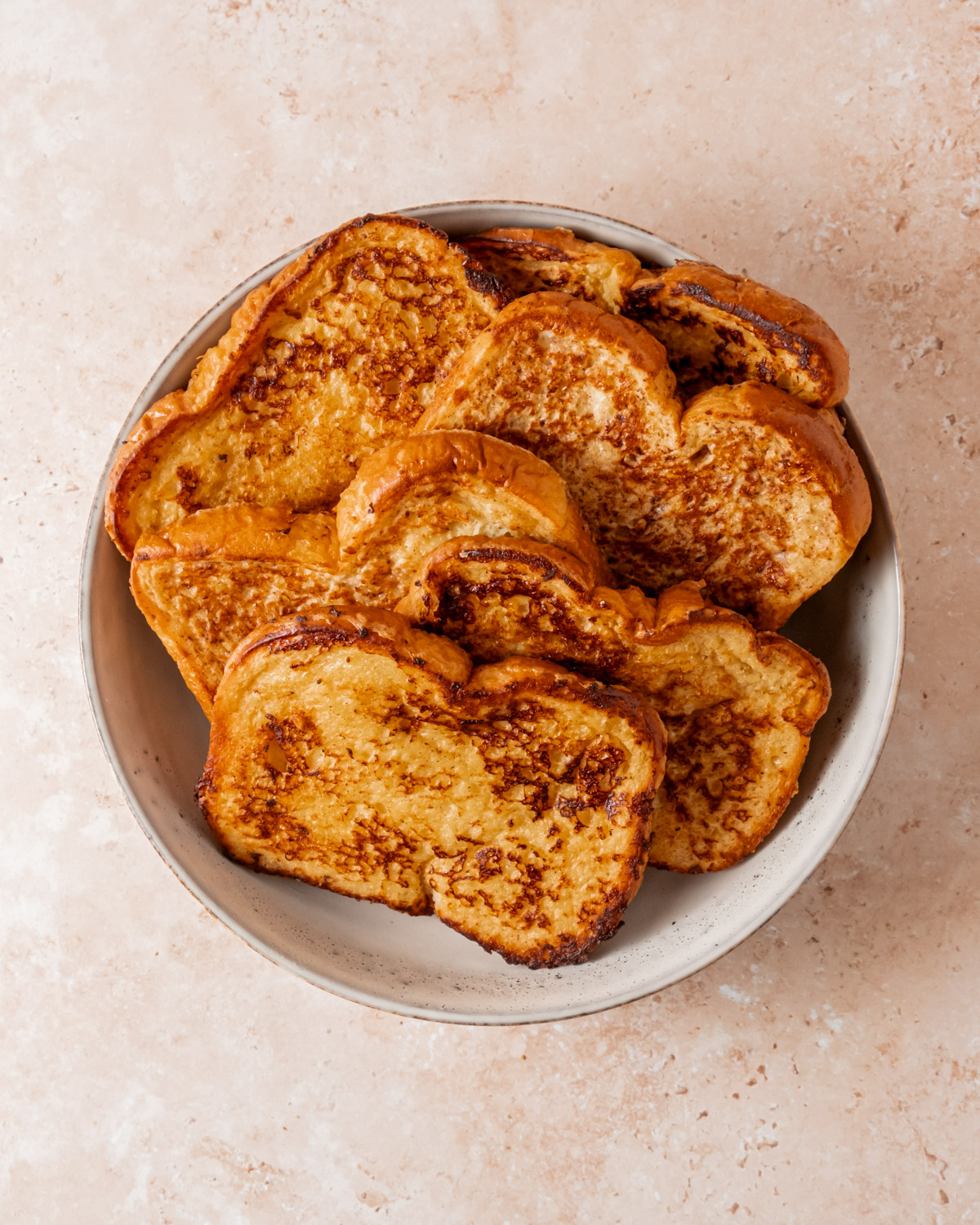 Slices of cooked French toast, perfectly browned and golden.