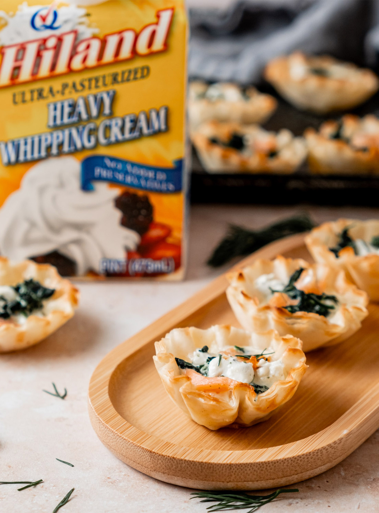 close up of Salmon and Goat Cheese Tartlets on a wooden serving tray