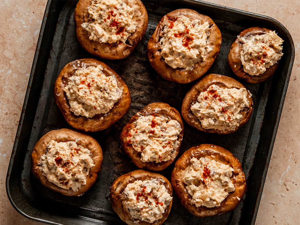 close up of Sausage Stuffed Mushrooms on metal baking tray